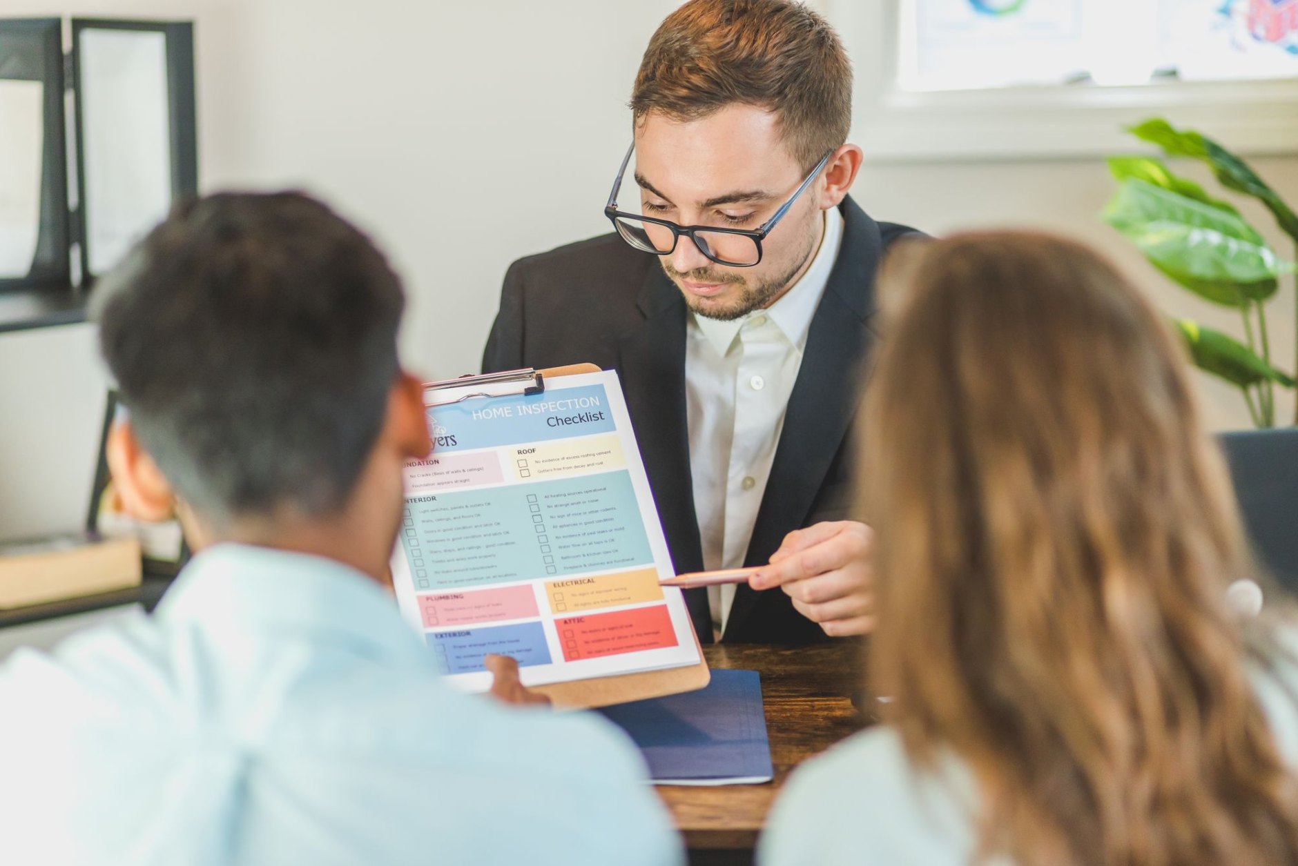 An adviser going through a printed plan with an older couple in an office
