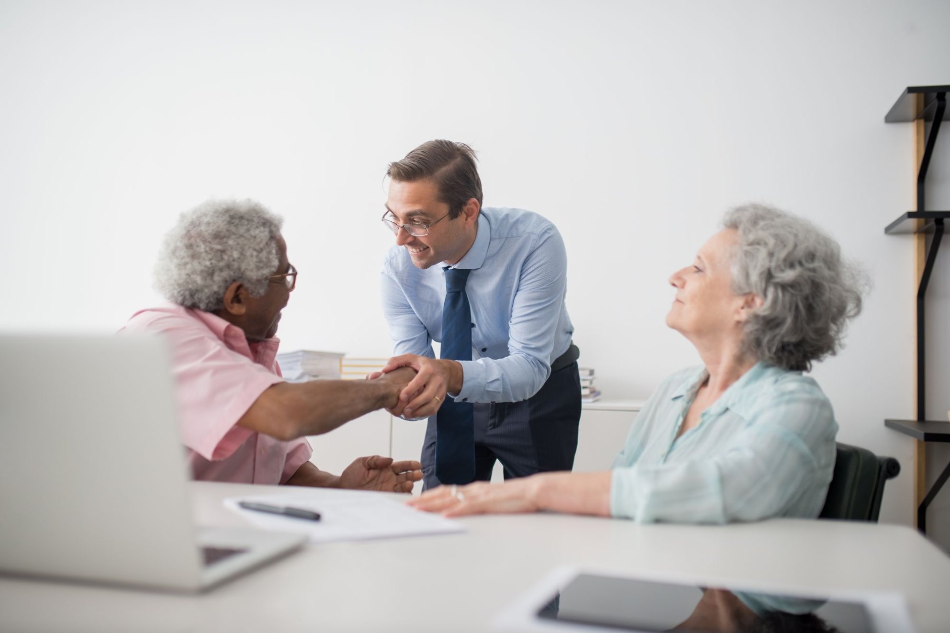 Advisers and clients talking around a table in a bright meeting room